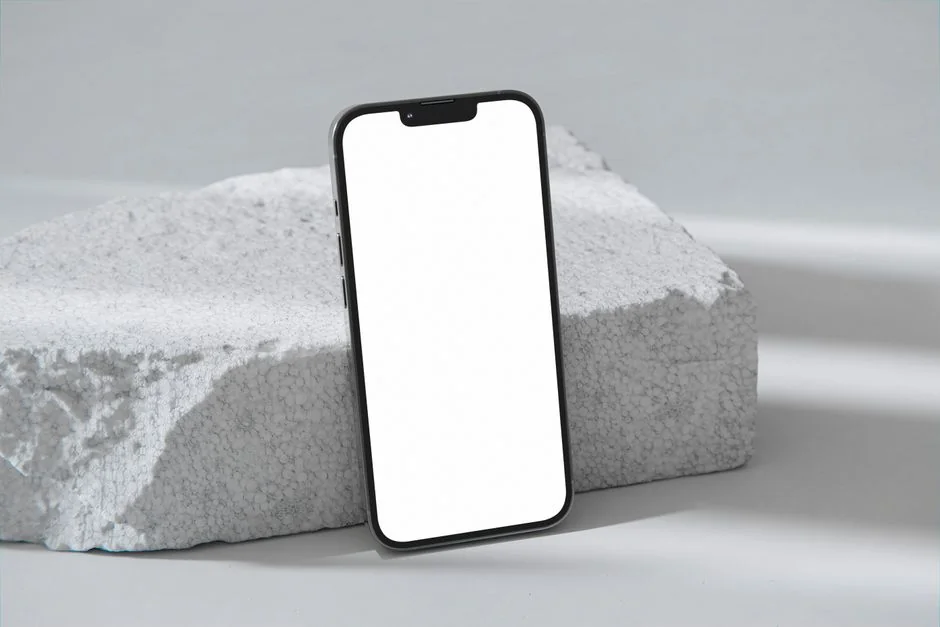 Top view of a minimalist setup featuring a tablet and smartphones on a white surface.